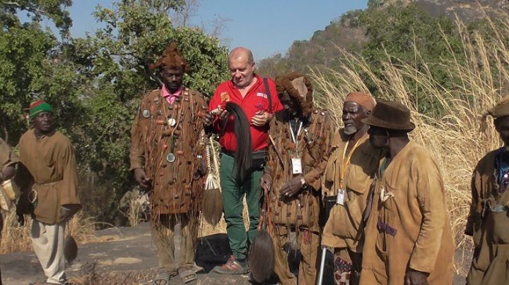 Le rôle traditionnel des chasseurs dozos expliqué à des touristes sur le mont Denguélé